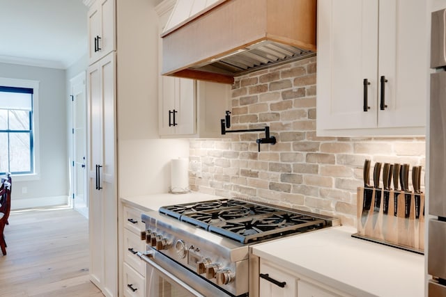 1036 Wilderness Way, Cottontown, TN 37048 - kitchen with high end stainless steel range, premium range hood, backsplash, light countertops, and white cabinets