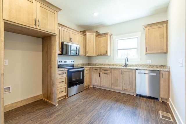 1189 Goose Dr, Springfield, TN 37172 - kitchen featuring appliances with stainless steel finishes, light brown cabinetry, dark wood-style flooring, light stone countertops, and recessed lighting