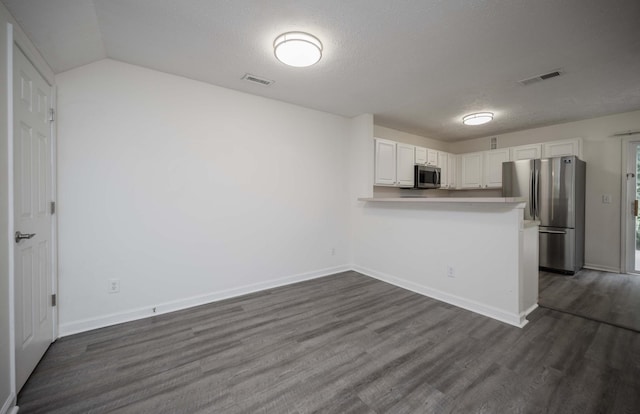 482 Flintlock Ct, Nashville, TN 37217 - kitchen featuring appliances with stainless steel finishes, white cabinetry, dark wood-style floors, a textured ceiling, and a peninsula