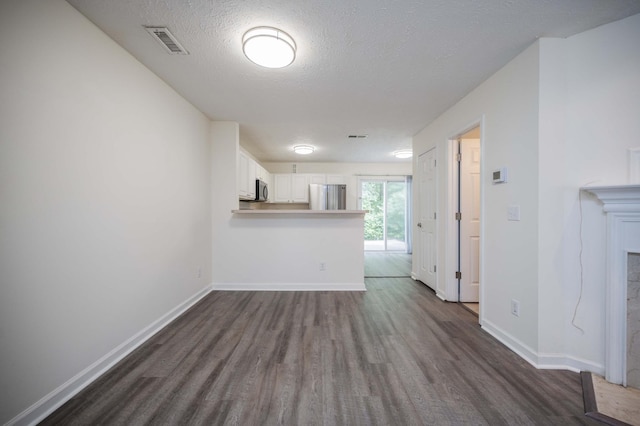 482 Flintlock Ct, Nashville, TN 37217 - unfurnished living room with dark wood finished floors, a textured ceiling, and a fireplace