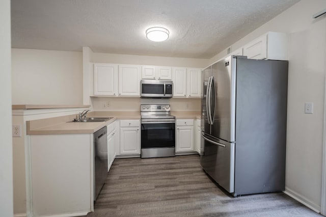 482 Flintlock Ct, Nashville, TN 37217 - kitchen with appliances with stainless steel finishes, dark wood-style floors, white cabinetry, a textured ceiling, and light countertops
