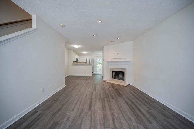 482 Flintlock Ct, Nashville, TN 37217 - unfurnished living room featuring dark wood-style floors, a high end fireplace, a textured ceiling, and recessed lighting
