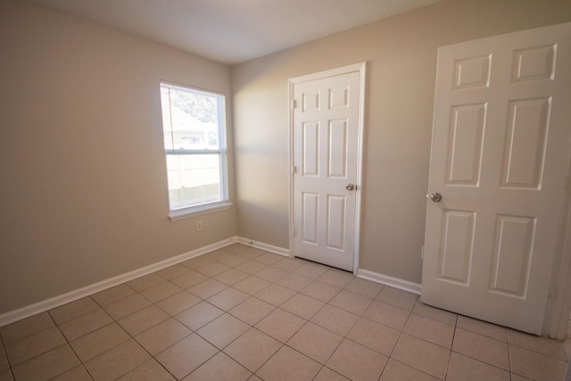 1611 12th Ave N, Nashville, TN 37208 - unfurnished bedroom with light tile patterned floors and baseboards