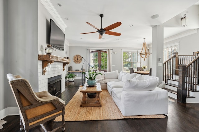 1711 Sevier St, Nashville, TN 37206 - living room featuring a fireplace, crown molding, stairs, ceiling fan, and dark wood-style floors