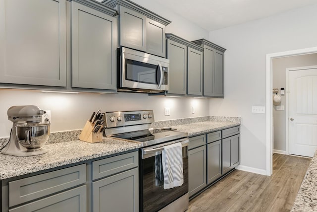 2122 Oak Dr, Murfreesboro, TN 37128 - kitchen featuring stainless steel appliances, gray cabinets, light wood-type flooring, and light stone countertops