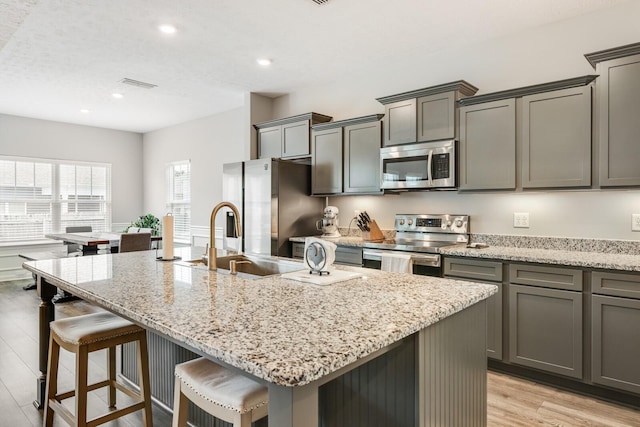 2122 Oak Dr, Murfreesboro, TN 37128 - kitchen with stainless steel appliances, light wood finished floors, a kitchen breakfast bar, light stone countertops, and recessed lighting