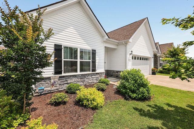 2122 Oak Dr, Murfreesboro, TN 37128 - view of front of home featuring an attached garage, stone siding, concrete driveway, a front lawn, and a shingled roof