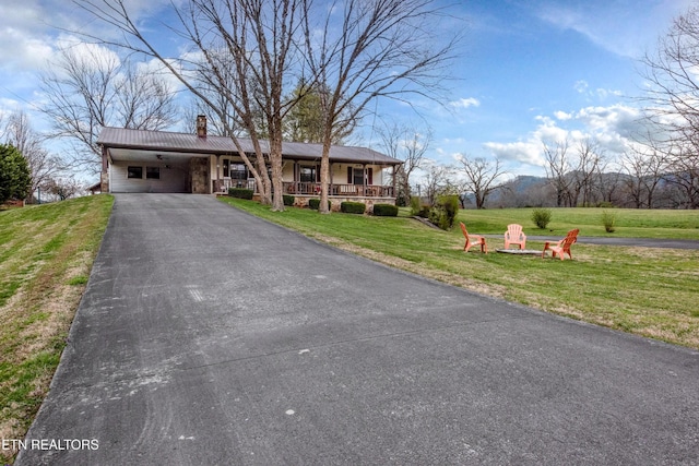 311 E Chestnut Hill Rd, Townsend, TN 37882 - ranch-style home featuring a chimney, a front yard, an outdoor fire pit, asphalt driveway, and an attached carport