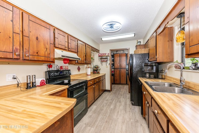 311 E Chestnut Hill Rd, Townsend, TN 37882 - kitchen featuring black electric range oven, under cabinet range hood, wooden counters, brown cabinets, and a textured ceiling