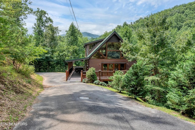 1615 Mountain Dreams Way, Sevierville, TN 37862 - log-style house with driveway, log siding, a wooded view, and a wooden deck
