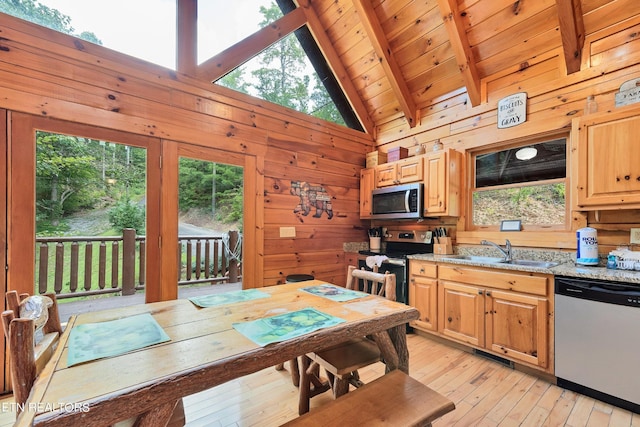 1615 Mountain Dreams Way, Sevierville, TN 37862 - kitchen with stainless steel appliances, wood walls, light wood finished floors, wooden ceiling, and light stone countertops