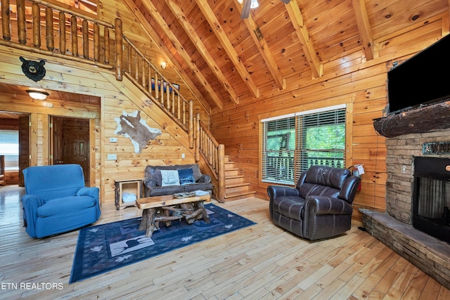 1615 Mountain Dreams Way, Sevierville, TN 37862 - living area with a fireplace, stairs, wood walls, hardwood / wood-style floors, and high vaulted ceiling