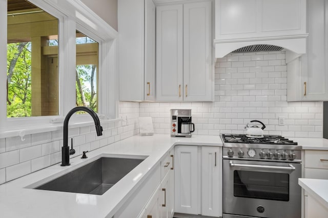 4253 Jamesborough Pl, Nashville, TN 37215 - kitchen with high end stainless steel range, decorative backsplash, light countertops, and white cabinetry