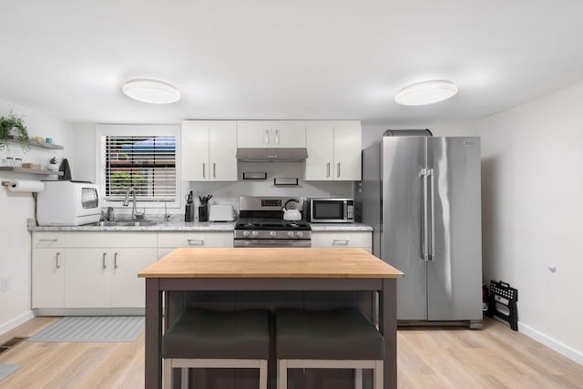 1795 Lake Logan Rd, Ardmore, TN 38449 - kitchen featuring stainless steel appliances, butcher block countertops, light wood-style flooring, under cabinet range hood, and white cabinetry