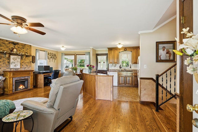 7180 Elrod Rd, Fairview, TN 37062 - living area featuring wood finished floors, ceiling fan, a fireplace, crown molding, and stairs