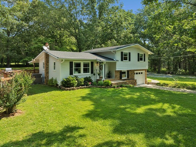 7180 Elrod Rd, Fairview, TN 37062 - split level home featuring a chimney, concrete driveway, a garage, and a front lawn