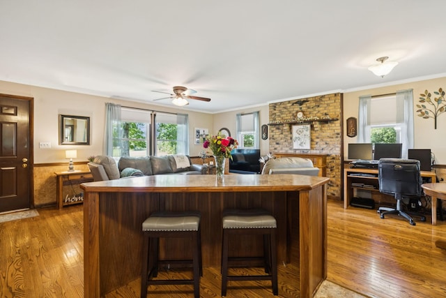 7180 Elrod Rd, Fairview, TN 37062 - kitchen featuring light wood finished floors, a ceiling fan, ornamental molding, an office area, and a breakfast bar