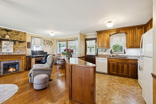 7180 Elrod Rd, Fairview, TN 37062 - kitchen with white appliances, open floor plan, a brick fireplace, ornamental molding, and a center island