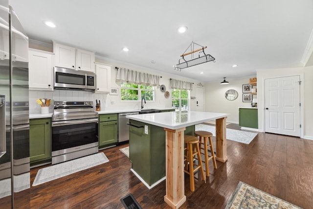 1704 Christi Ave, Chapel Hill, TN 37034 - kitchen featuring appliances with stainless steel finishes, green cabinetry, a kitchen island, light countertops, and ornamental molding