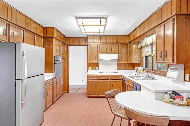 89 Belmar Cir, Manchester, TN 37355 - kitchen featuring white appliances, brown cabinets, light countertops, wooden walls, and a textured ceiling