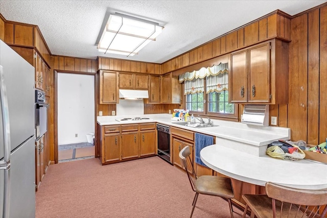 89 Belmar Cir, Manchester, TN 37355 - kitchen featuring black appliances, under cabinet range hood, brown cabinets, wood walls, and light countertops