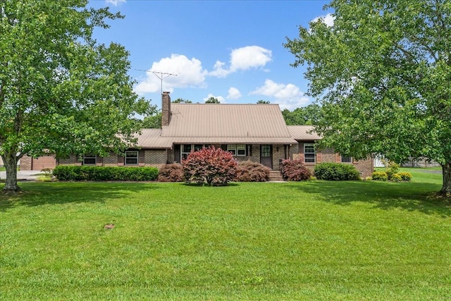 89 Belmar Cir, Manchester, TN 37355 - view of front of home with a chimney, a front lawn, brick siding, and a metal roof