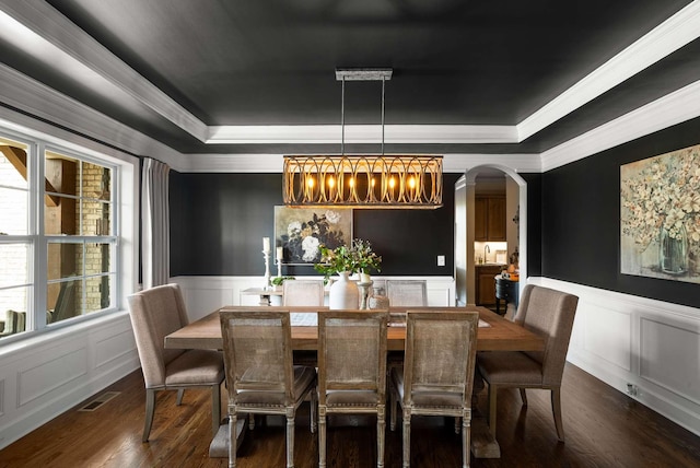 800 Singleton Ln, Brentwood, TN 37027 - dining space featuring a raised ceiling, a decorative wall, dark wood-style floors, arched walkways, and crown molding