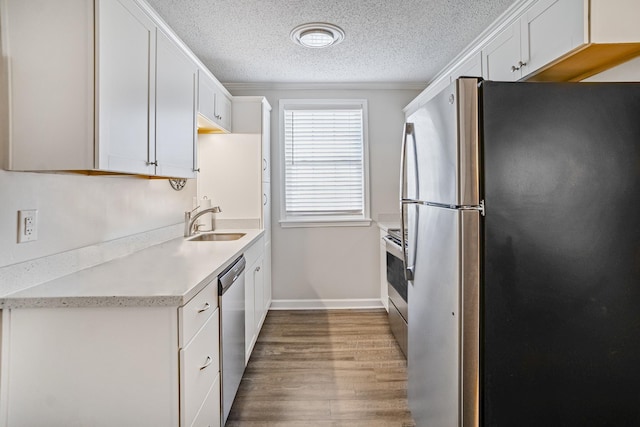 1301 Neelys Bend Rd Unit 14, Madison, TN 37115 - kitchen featuring appliances with stainless steel finishes, wood finished floors, light countertops, a textured ceiling, and white cabinetry