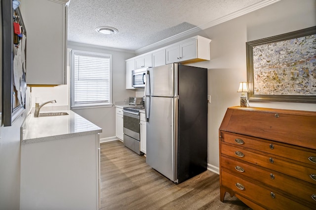 1301 Neelys Bend Rd Unit 14, Madison, TN 37115 - kitchen with appliances with stainless steel finishes, light wood finished floors, ornamental molding, light countertops, and a textured ceiling