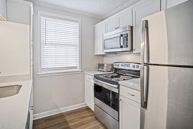 1301 Neelys Bend Rd Unit 14, Madison, TN 37115 - kitchen with appliances with stainless steel finishes, dark wood-type flooring, white cabinetry, crown molding, and light countertops