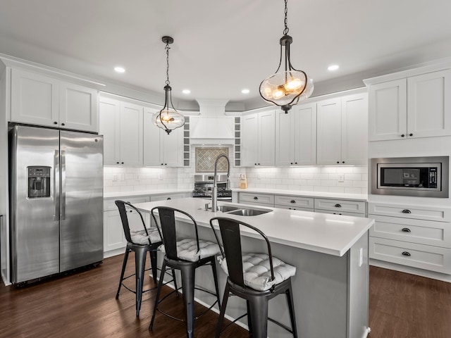 71 Windjammer Ct, Winchester, TN 37398 - kitchen with stainless steel appliances, light countertops, a kitchen island with sink, decorative light fixtures, and a kitchen bar