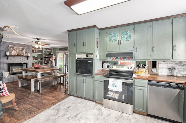 10 Clinton Rd, Humboldt, TN 38343 - kitchen featuring appliances with stainless steel finishes, a ceiling fan, tasteful backsplash, and a fireplace