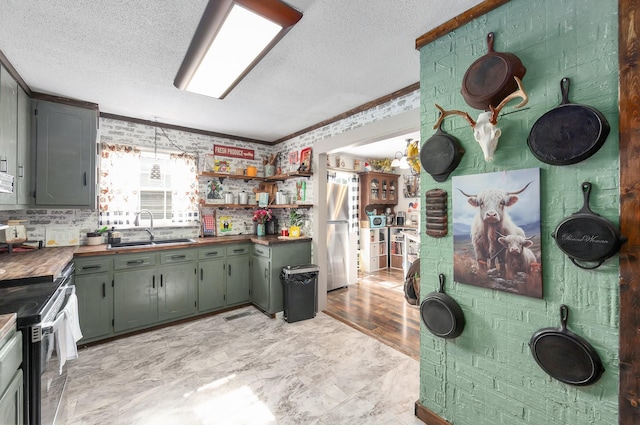 10 Clinton Rd, Humboldt, TN 38343 - kitchen with appliances with stainless steel finishes, a textured ceiling, crown molding, gray cabinetry, and open shelves
