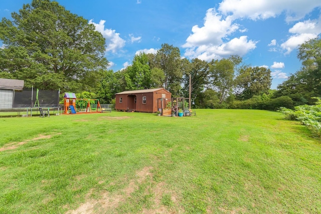 10 Clinton Rd, Humboldt, TN 38343 - view of green lawn featuring a trampoline, a playground, a storage unit, and view of scattered trees