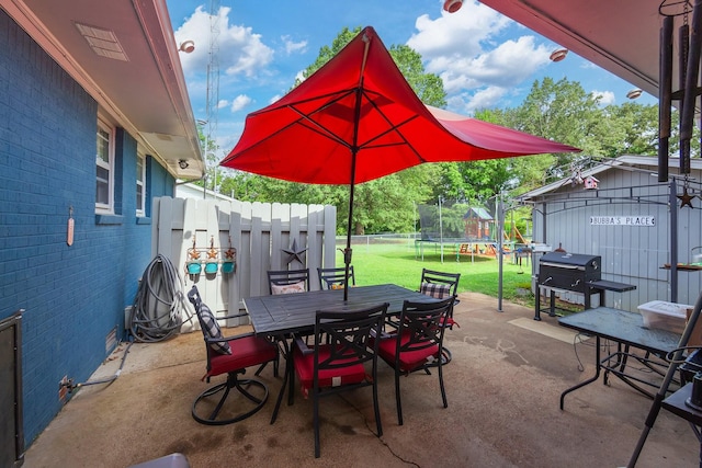10 Clinton Rd, Humboldt, TN 38343 - view of patio featuring a trampoline, outdoor dining area, grilling area, and an outbuilding