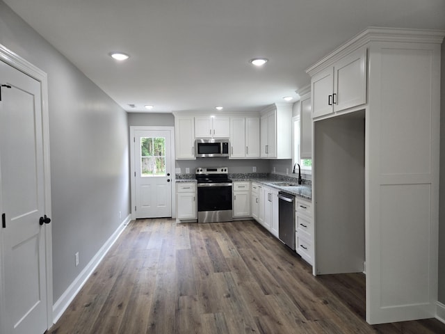 504 1st St, Lawrenceburg, TN 38464 - kitchen featuring stainless steel appliances, light stone countertops, white cabinets, dark wood-style floors, and recessed lighting