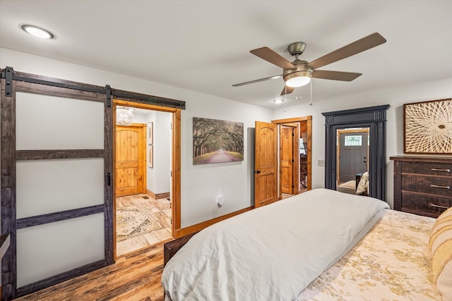 634 Cowboy Way, Jamestown, TN 38556 - bedroom featuring a barn door, wood finished floors, and a ceiling fan