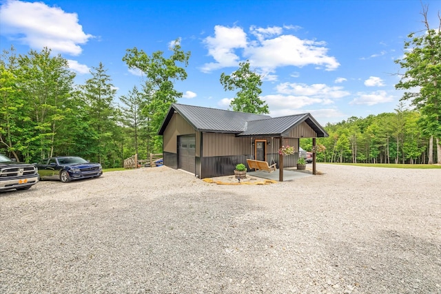 634 Cowboy Way, Jamestown, TN 38556 - view of property exterior with a metal roof, gravel driveway, and a view of trees