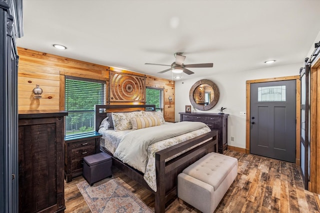 634 Cowboy Way, Jamestown, TN 38556 - bedroom with a barn door, wood finished floors, ceiling fan, recessed lighting, and wood walls
