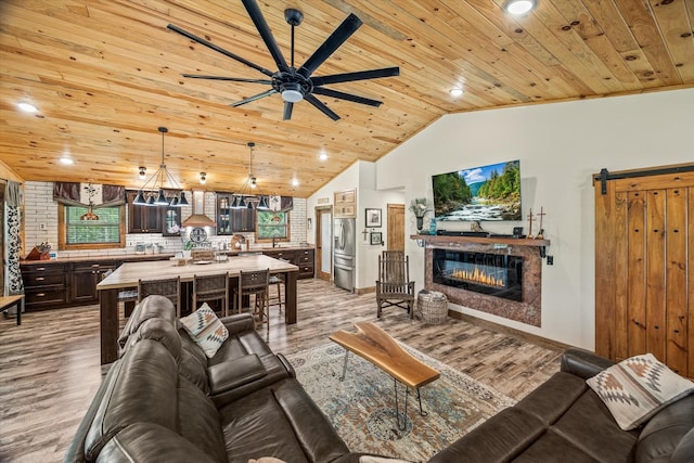 634 Cowboy Way, Jamestown, TN 38556 - living room with wood ceiling, light wood-style flooring, vaulted ceiling, a ceiling fan, and a glass covered fireplace