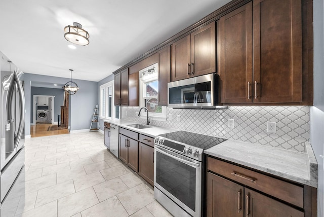 4921 Sango Rd, Clarksville, TN 37043 - kitchen featuring appliances with stainless steel finishes, dark brown cabinetry, backsplash, washer / clothes dryer, and light stone counters