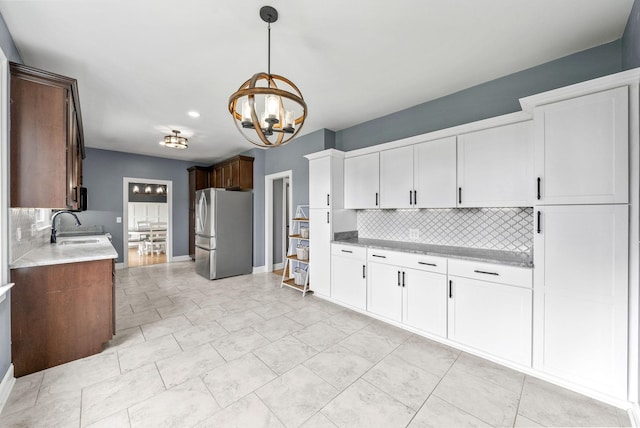4921 Sango Rd, Clarksville, TN 37043 - kitchen with freestanding refrigerator, decorative backsplash, light countertops, a chandelier, and recessed lighting