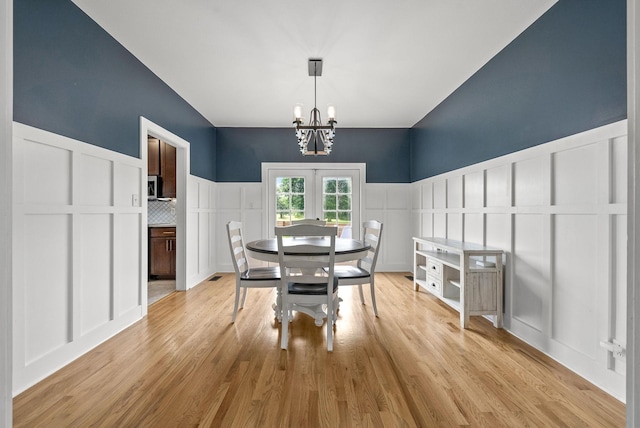 4921 Sango Rd, Clarksville, TN 37043 - dining area with a decorative wall, a chandelier, light wood-style flooring, and a wainscoted wall