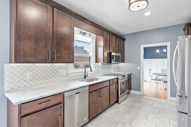 4921 Sango Rd, Clarksville, TN 37043 - kitchen featuring appliances with stainless steel finishes, tasteful backsplash, light stone counters, and dark brown cabinets
