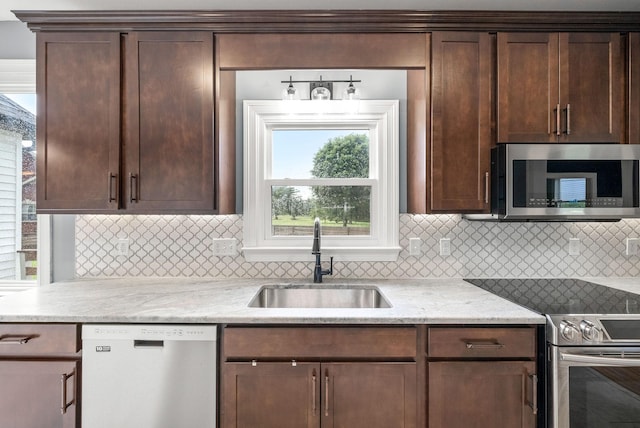 4921 Sango Rd, Clarksville, TN 37043 - kitchen featuring appliances with stainless steel finishes, dark brown cabinetry, decorative backsplash, and light stone counters