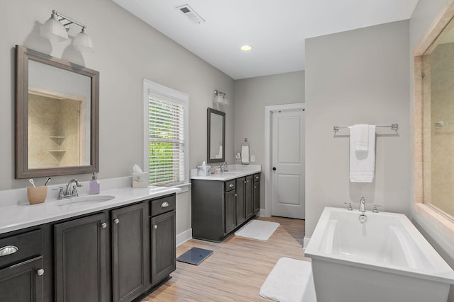 730 Fontwell Ln, Franklin, TN 37064 - bathroom featuring a tub to relax in, two vanities, wood finished floors, a tile shower, and recessed lighting