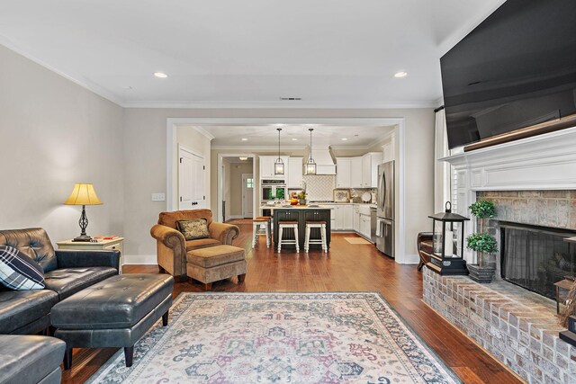 730 Fontwell Ln, Franklin, TN 37064 - living room featuring dark wood-style flooring, a brick fireplace, ornamental molding, and recessed lighting