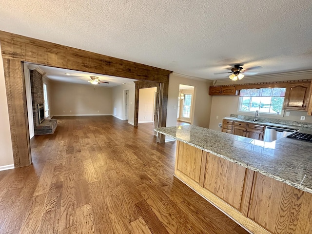 1759 Ardmore Hwy, Taft, TN 38488 - kitchen featuring a ceiling fan, a textured ceiling, wood finished floors, light stone countertops, and crown molding