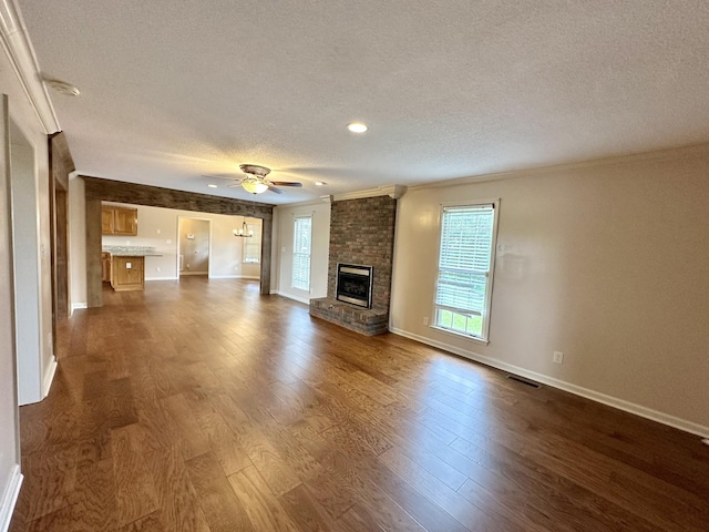 1759 Ardmore Hwy, Taft, TN 38488 - unfurnished living room with a textured ceiling, a fireplace, crown molding, dark wood-type flooring, and a ceiling fan