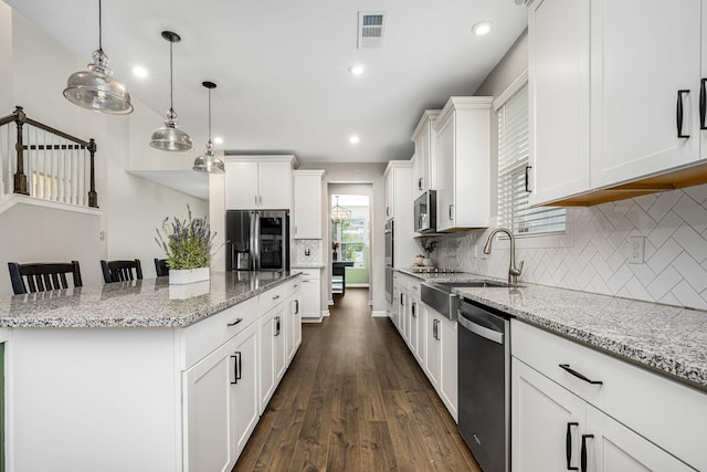 810 Corlew St, Murfreesboro, TN 37130 - kitchen featuring stainless steel appliances, a center island, dark wood-type flooring, white cabinetry, and light stone countertops
